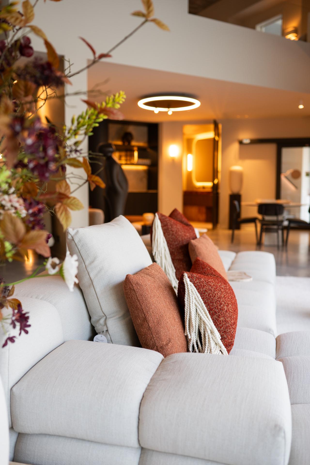 Zachte stoffen, decoratieve kussens en warme verlichting in een exclusieve woonkamer